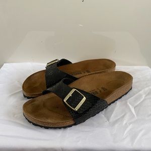 One strap Birkenstocks with black snake skin pattern